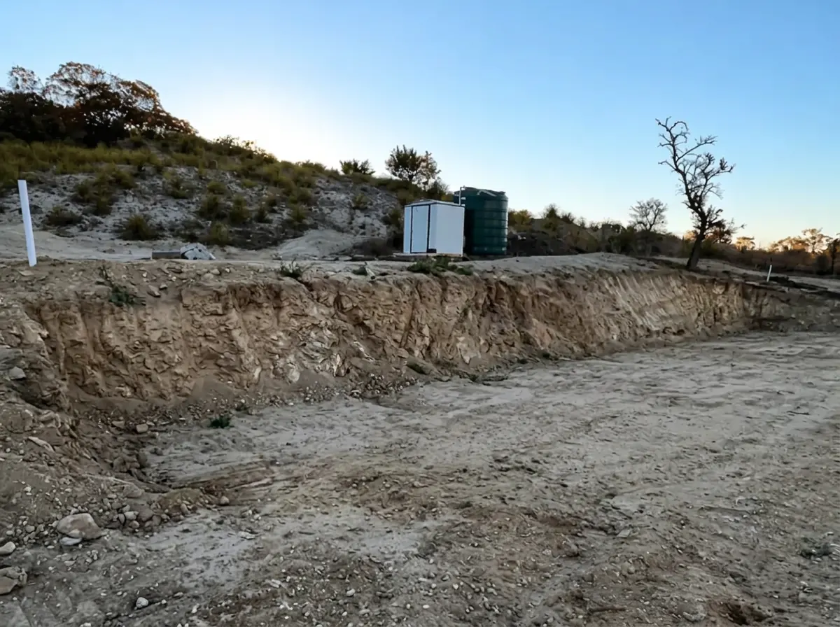 Bare cut hillside bank before the retaining wall was built